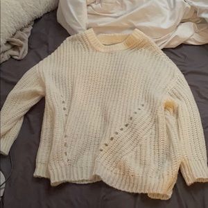 large cream colored sweater but could fit an XL